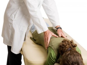 Patient with green sweater receives chiropractic care