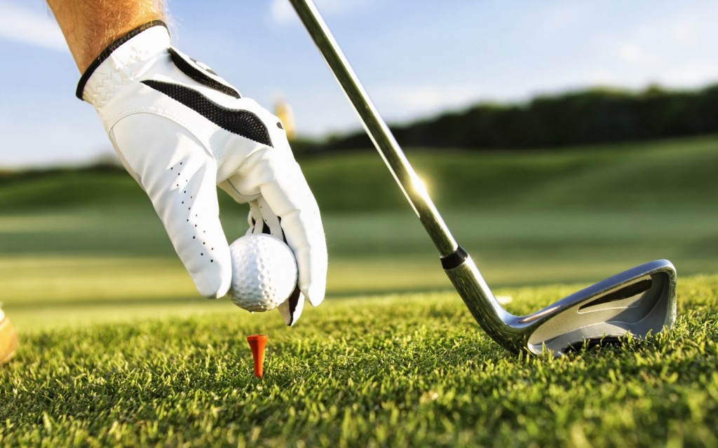 Golfer puts golfball on tee