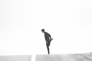 Silhouetted runner stretching