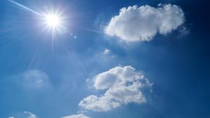 sunshine and blue sky with fluffy, white clouds