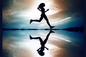 Silhouette of someone running near reflective surface in front of interesting sky.