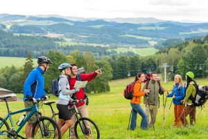 Two groups of active people outdoors, one preparing for a hike and the other a bike ride.