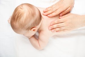 Closeup of chiropractor's hands giving chiropractic adjustment to baby