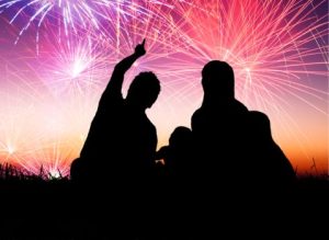 happy family sitting on floor and watching the fireworks
