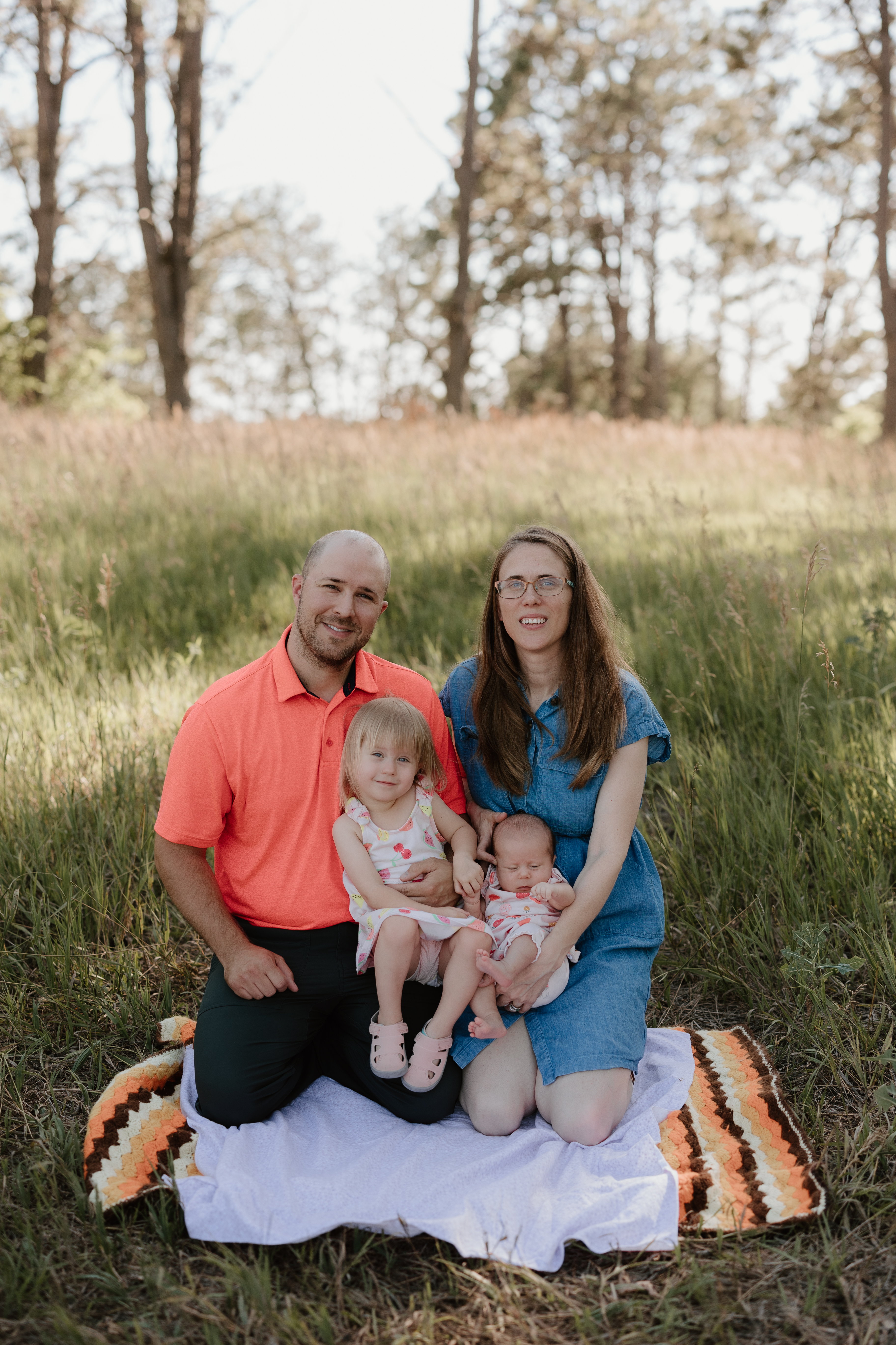 family with man, woman, young child and dog, all smiling